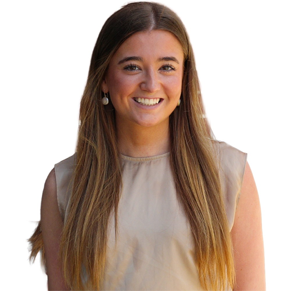 Portrait of a smiling young woman with long light brown hair, wearing a beige sleeveless top and small earrings.