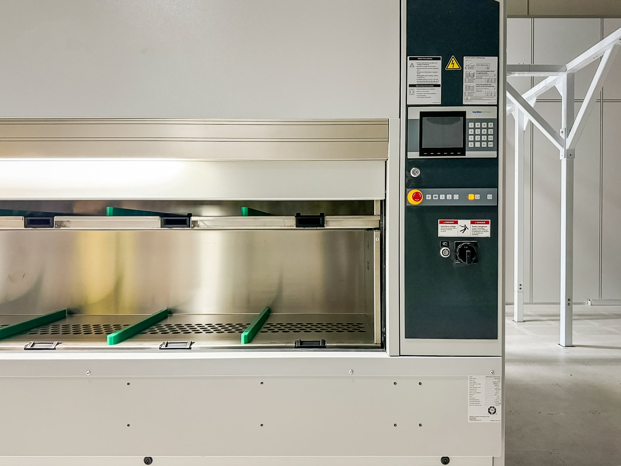 Industrial packaging machine with a control panel on the right and green conveyor guides