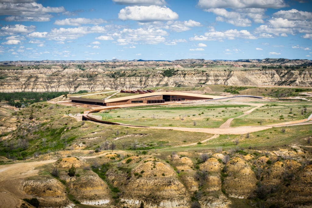Aerial view of the Theodore Roosevelt Presidential Library integrated into the North Dakota Badlands landscape.