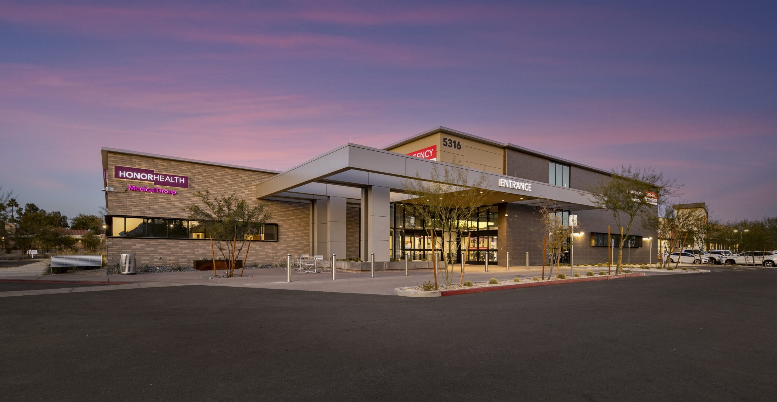 HonorHealth CC Shea_E_H_Entrance Dusk | JE Dunn Construction Exterior view of the HonorHealth Medical Group hospital at dusk, showing the main entrance and modern glass doors.
